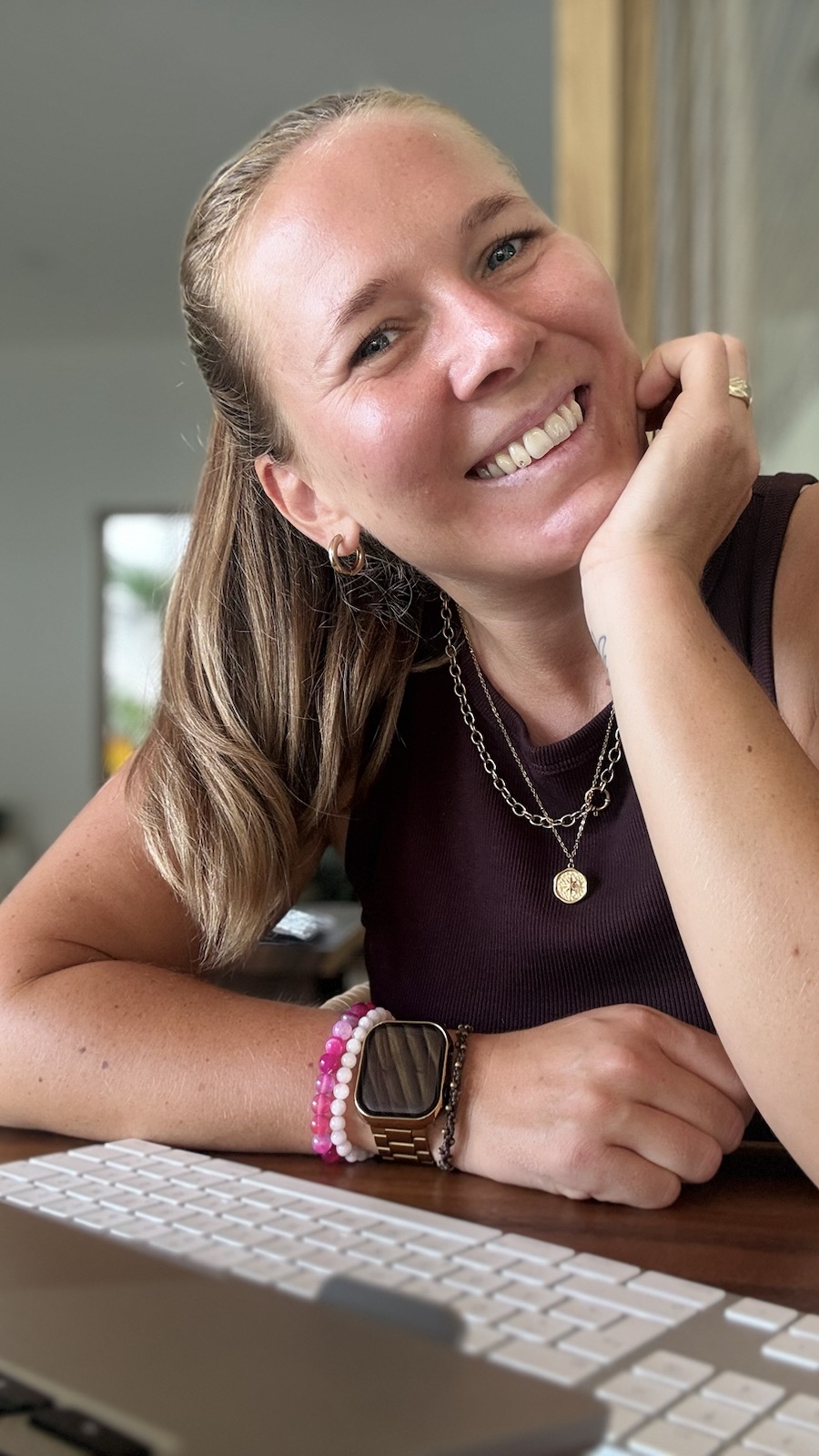 Martina lächelt an ihrem Arbeitsplatz in die Kamera.
